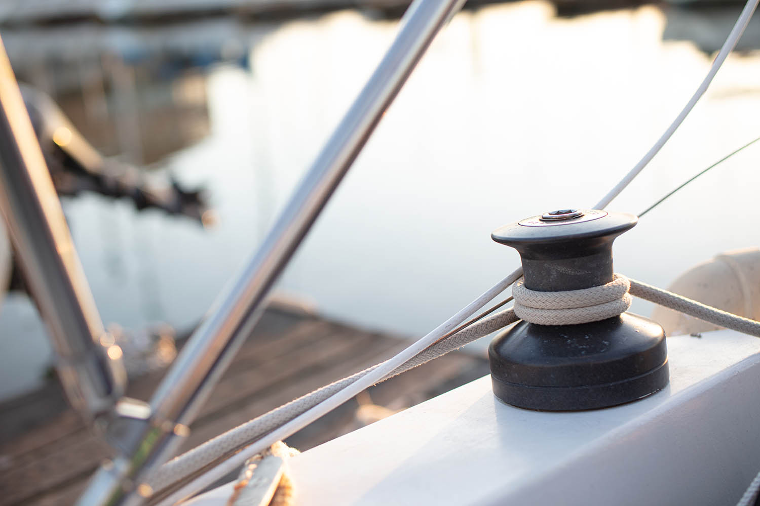 Bootankerblok met touw en kabel, rond een roestvrijstalen rand op een boot.